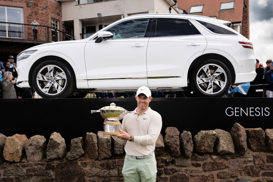 2023 제네시스 스코티시 오픈 우승자 로리 매킬로이가 부상으로 받은 GV70 전동화 모델 앞에서 우승트로피를 들고 있다. 제네시스 브랜드 제공